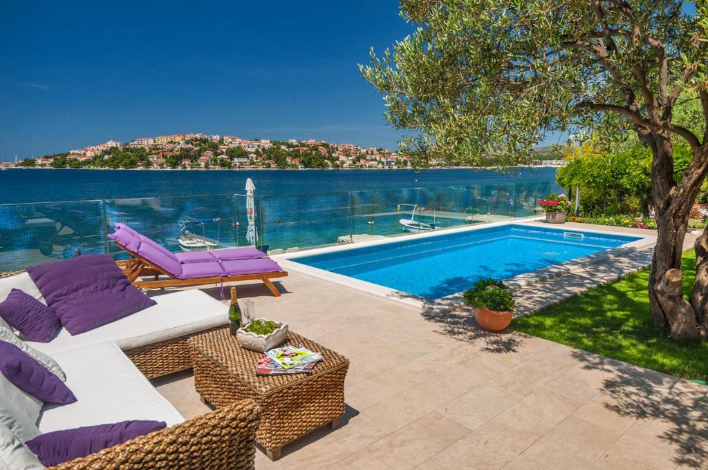 een villa met een zwembad met paarse meubels bij Villa Lucmar - swimming pool in Podglavica
