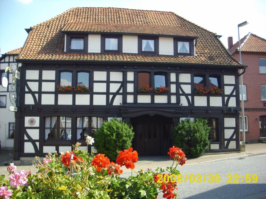 a black and white house with flowers in front of it at Schökel´s Hotel und Restaurant in Elze
