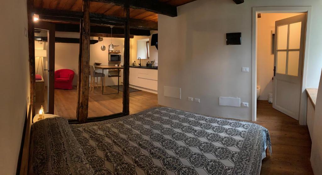 ein Schlafzimmer mit einem Bett in einem Zimmer mit einer Küche in der Unterkunft Casa Pietra in Trontano