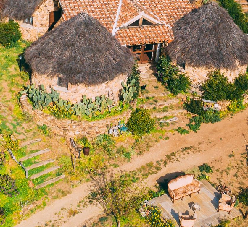 a model of a house with a grass roof at Essenza Sardegna in Torpè