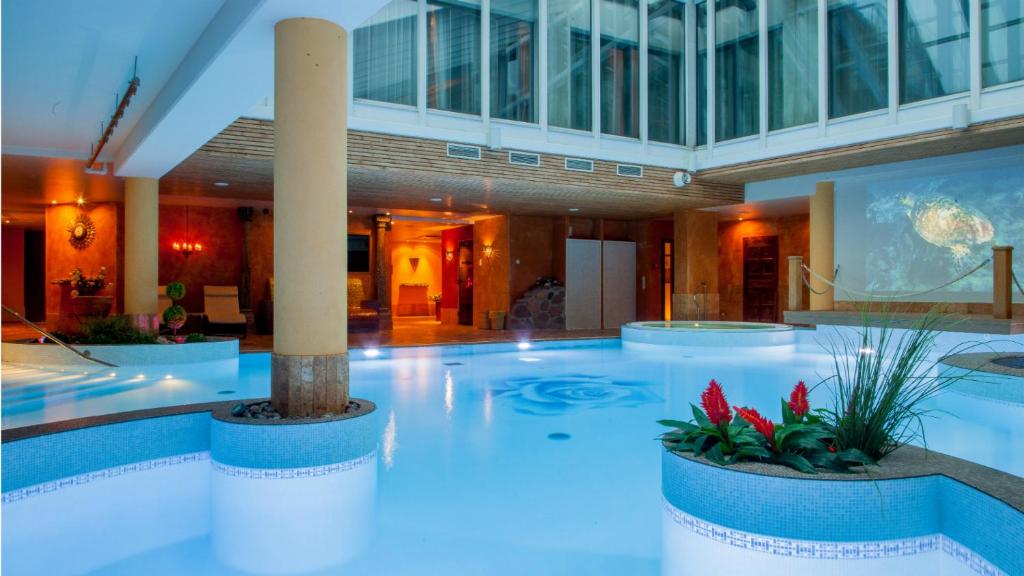 - une grande piscine dans un grand bâtiment dans l'établissement Grand Rose SPA Hotel, à Kuressaare