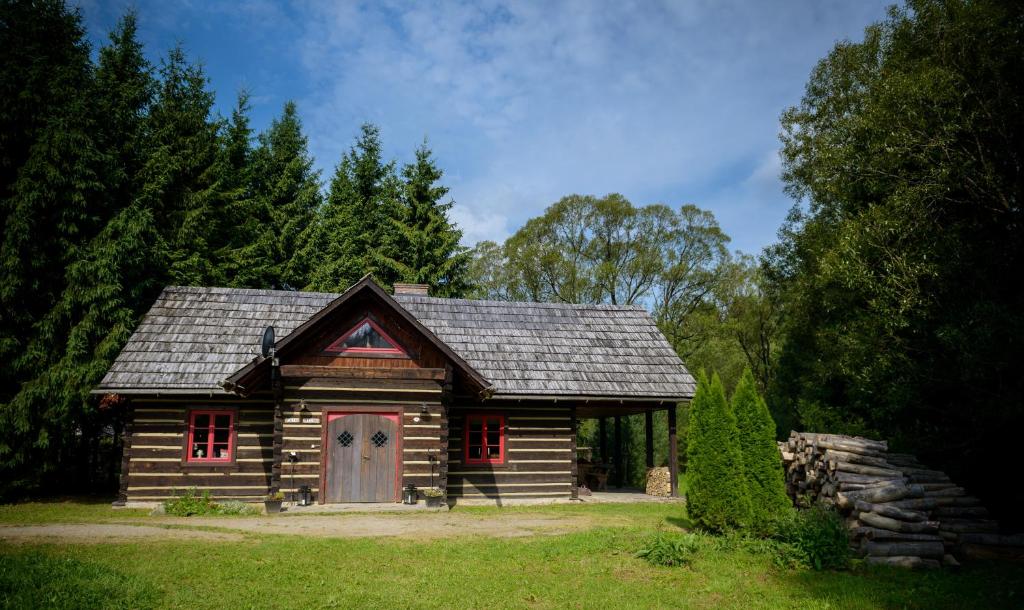 Cette petite cabane en bois dispose de fenêtres rouges et d'un toit. dans l'établissement Gata Negra, à Wetlina