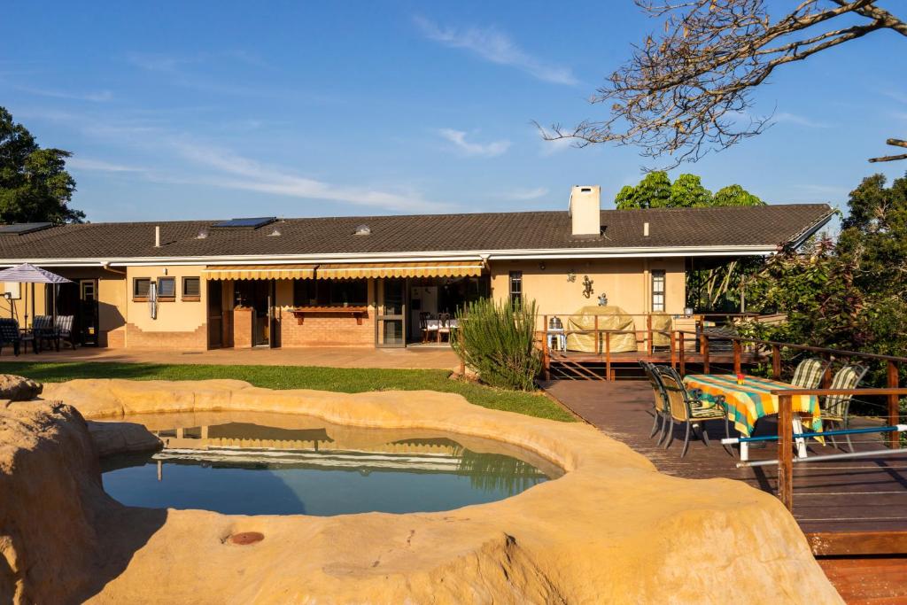 a house with a pool in front of a yard at The Anchorage Krantzkloof in Kloof