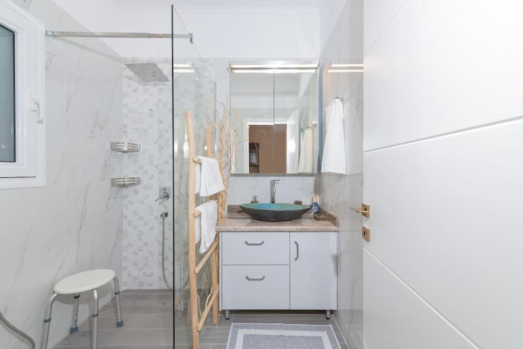 łazienka z umywalką i przeszkloną kabiną prysznicową w obiekcie Casa Aelia, luxury apartment w Korfu