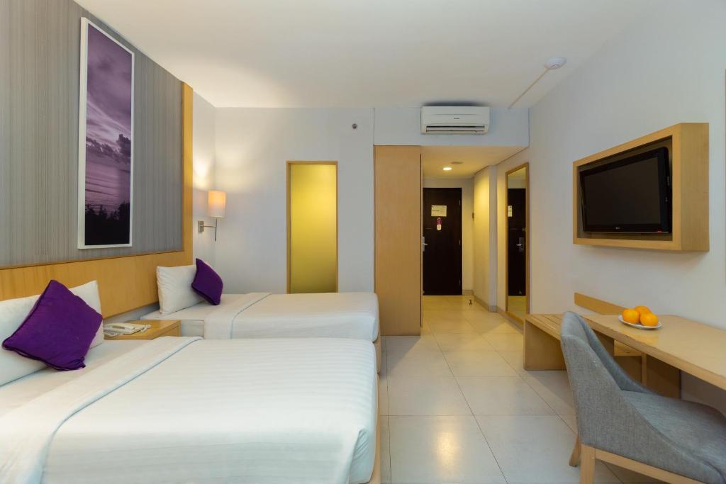 Postel nebo postele na pokoji v ubytování Quest Hotel Kuta by ASTON