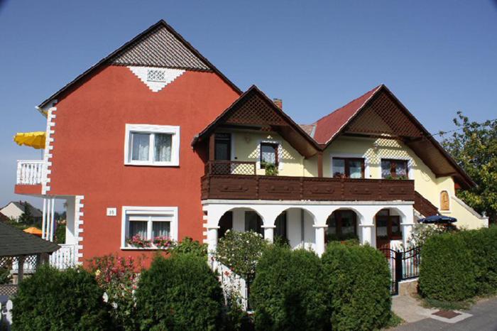 Maison rouge et blanche avec clôture dans l'établissement Papp Apartmanház, à Vonyarcvashegy