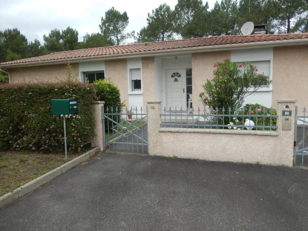 a house with a gate and a dog in a window at Villa De Guénifey in Josse