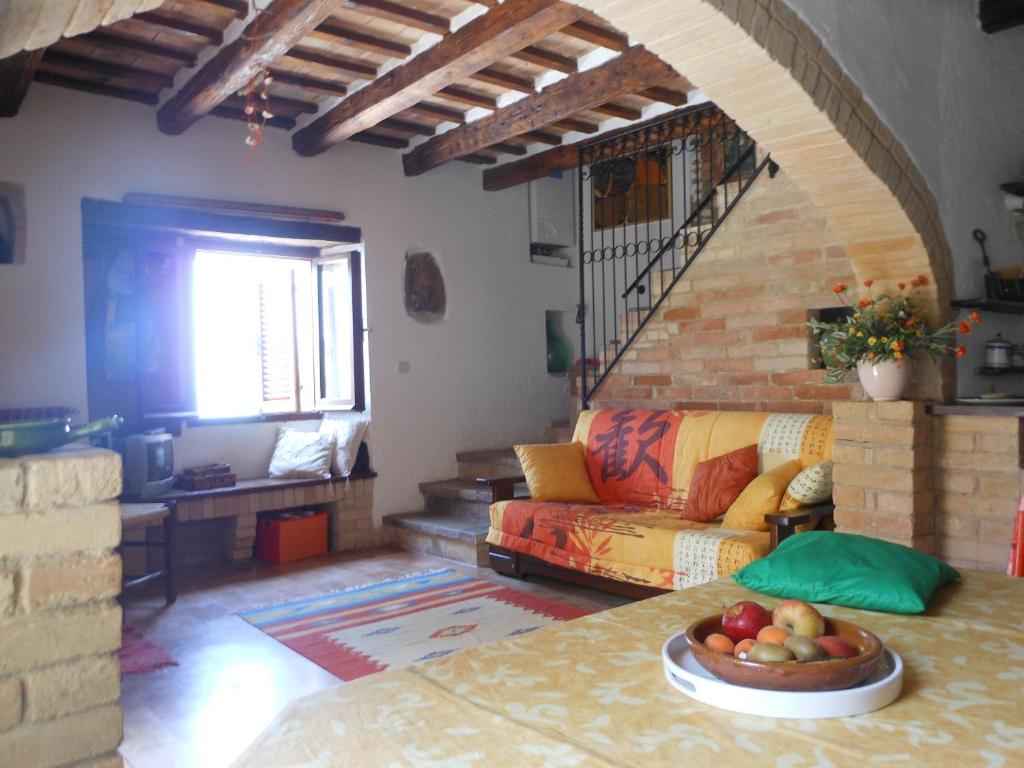 a living room with a couch and a bowl of fruit on a table at Casa Elena sul mare a Torre di Palme in Marina Palmense