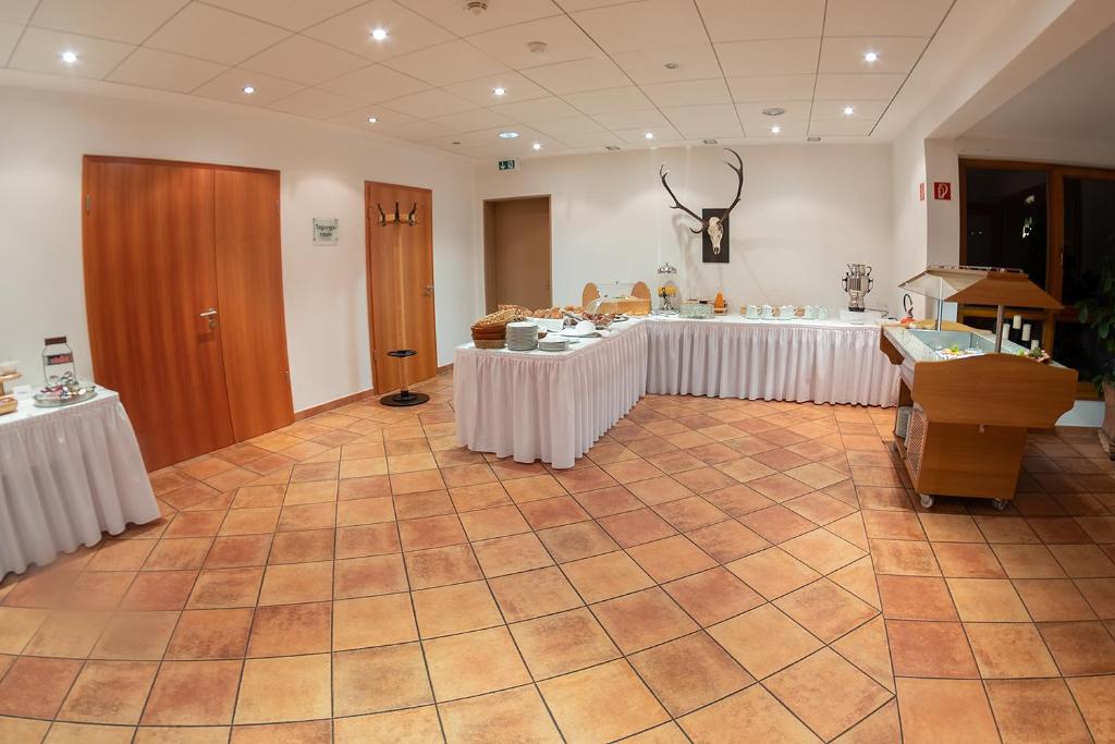 a large room with tables with white table cloth at Landhotel Aschenbrenner in Freudenberg