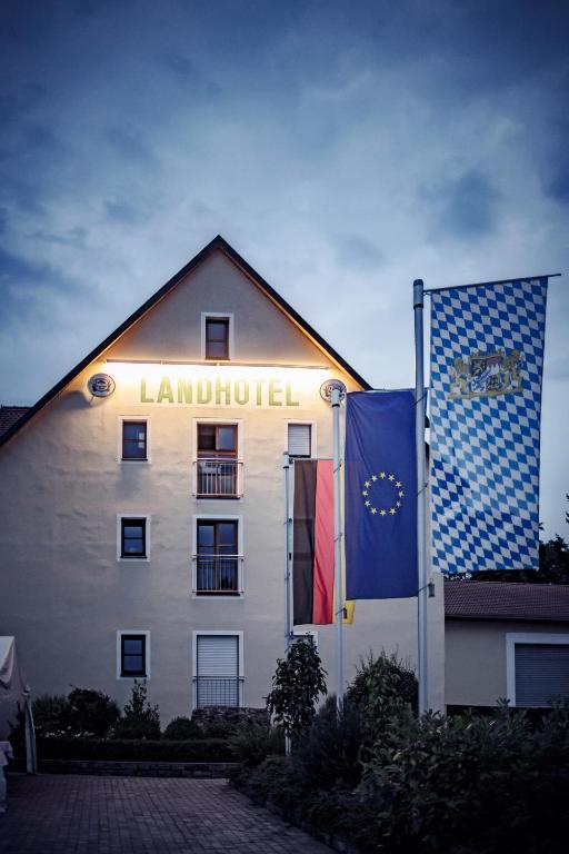 a building with two flags in front of it at Landhotel Aschenbrenner in Freudenberg