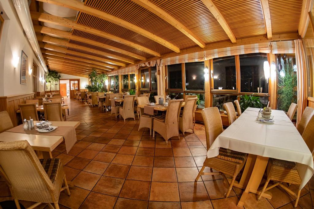 a restaurant with tables and chairs and windows at Landhotel Aschenbrenner in Freudenberg