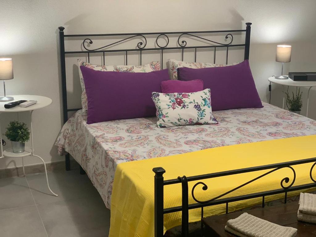 um quarto com uma cama com almofadas roxas e roxas em Aus Holiday Catania em Catânia