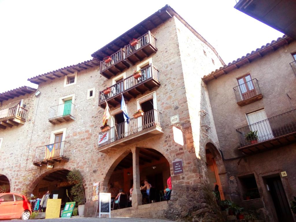 a building with people sitting on the balconies of it at CAN MENCIÓ - Plaça Major in Santa Pau