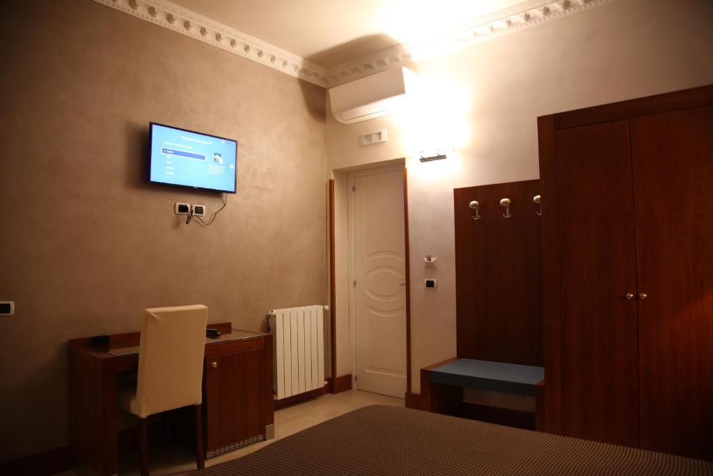 una camera con scrivania e TV sul muro di Federica's Home a Roma