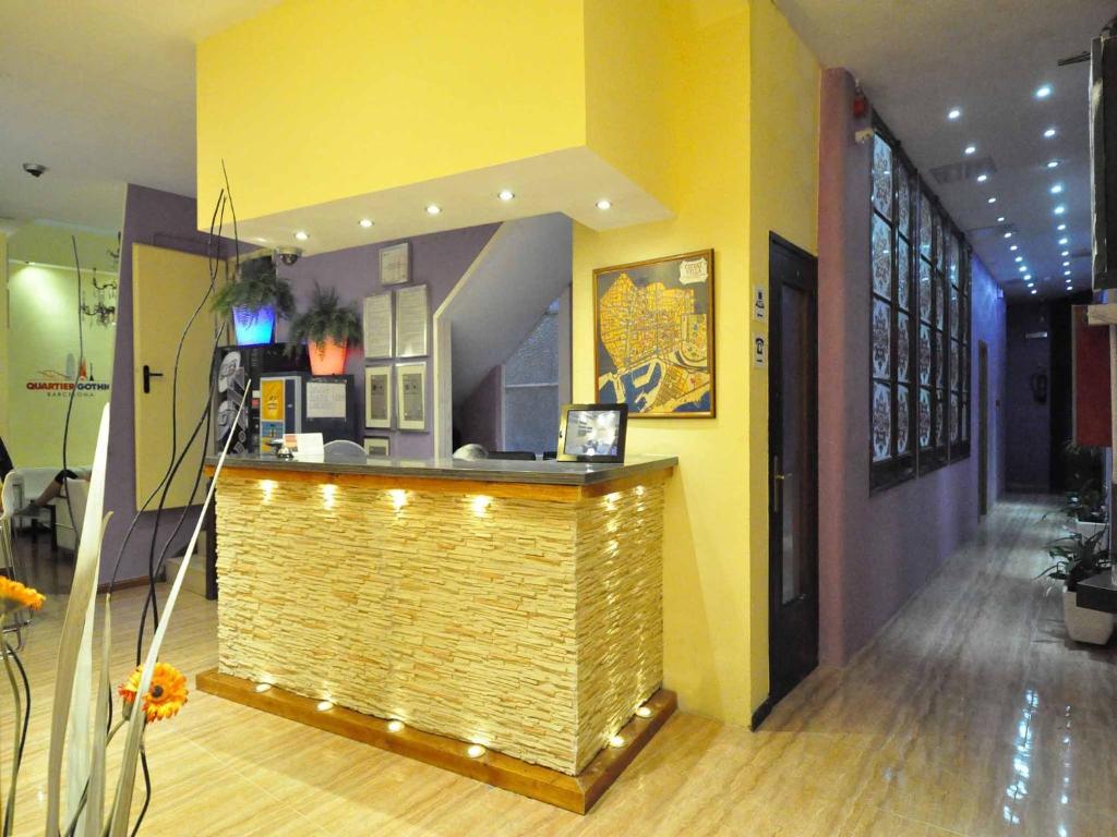 a bar in a room with a yellow wall at BARCELONA GOTIC Guesthouse in Barcelona