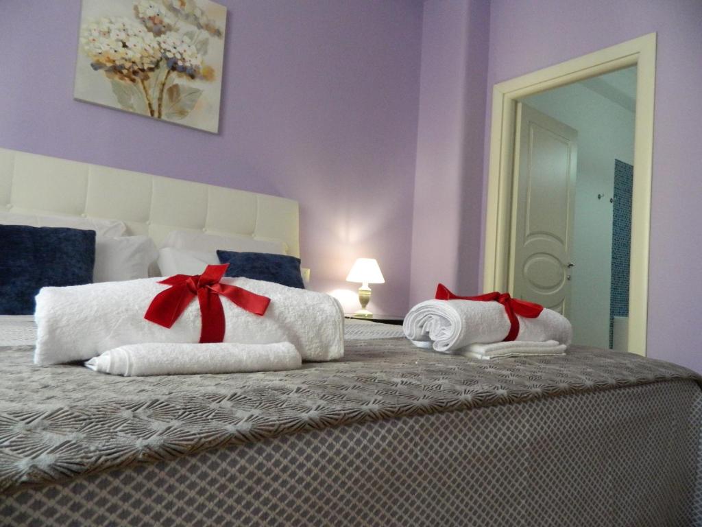 a bedroom with a bed with white towels and red bows at LE STANZE DI LUCA in Palermo