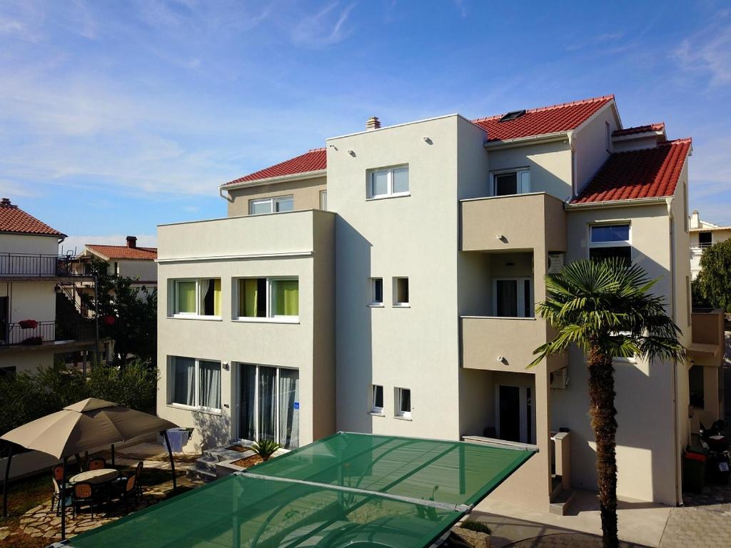 un edificio con una pista de tenis delante en FeWo Mira, en Vodice