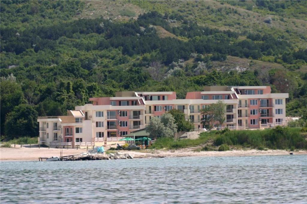 a large building on the beach next to the water at Sea Paradise Apartment Complex in Kavarna