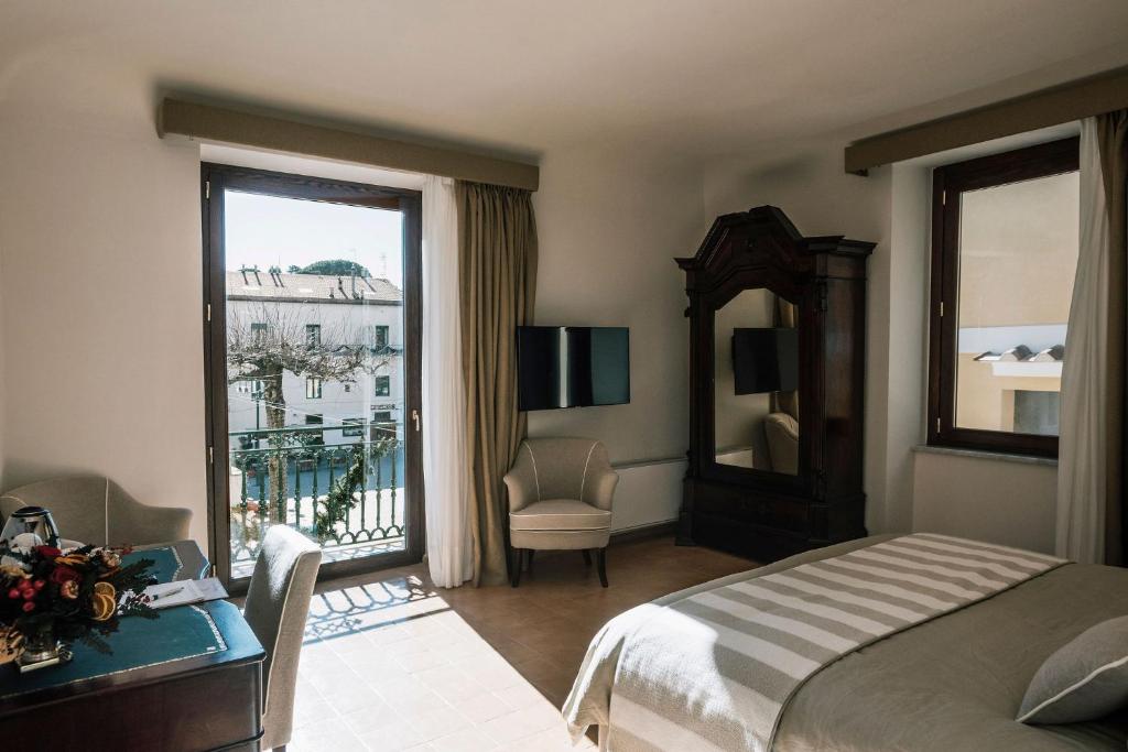 1 dormitorio con cama y ventana con vistas en Giardini Calce - Luxury Rooms, en Ravello