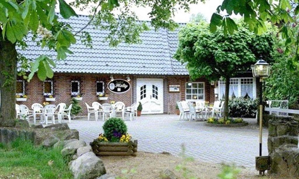 a brick house with white chairs in front of it at Gästehaus Höltig in Havekost