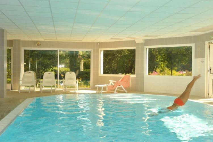 a boy in a swimming pool in a house at Logis Hôtel Le Relais du Moulin in Valençay