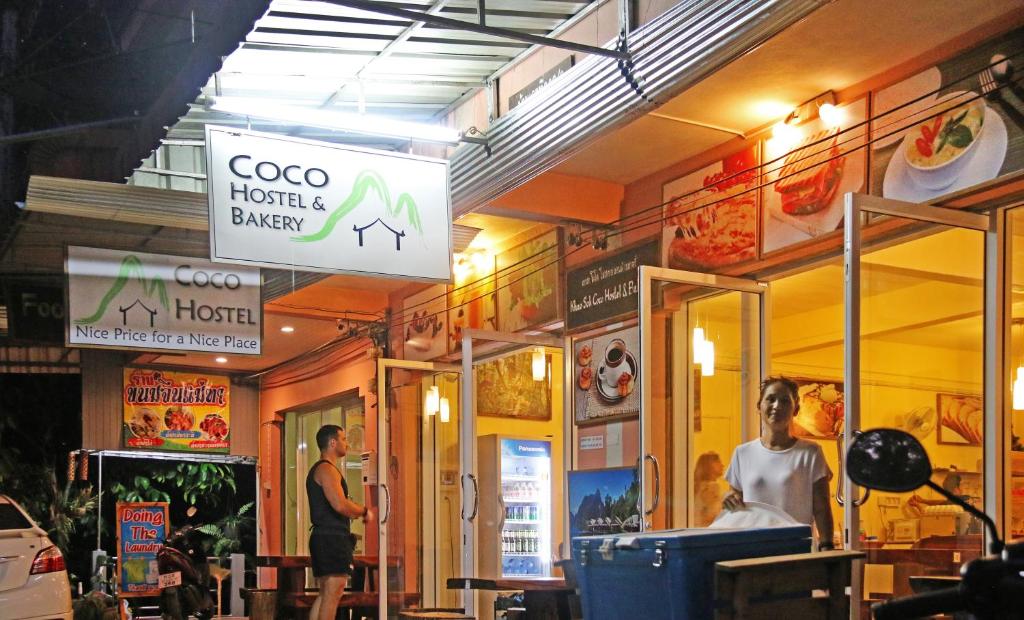 un hombre está parado fuera de un restaurante en Coco Khao Sok Hostel, en Khao Sok