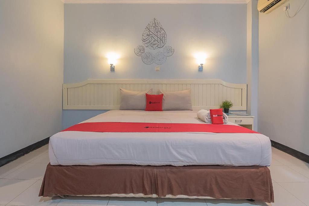 Postel nebo postele na pokoji v ubytování RedDoorz Syariah at Grand Taufiq Tarakan