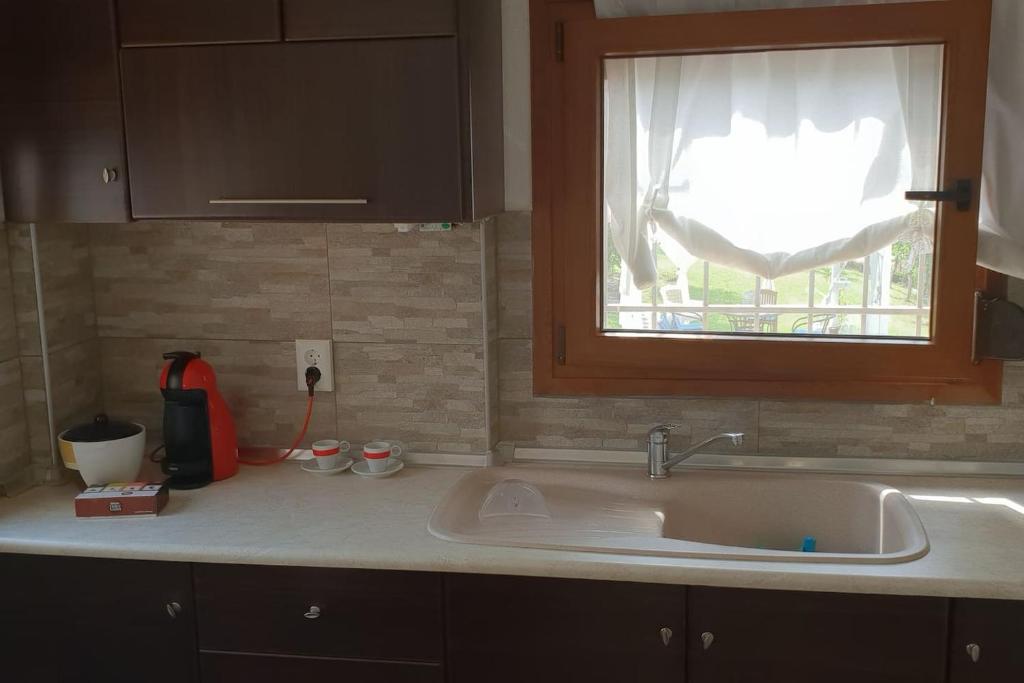 a kitchen counter with a sink and a window at Maria's Luxury Apartment in Kassandra