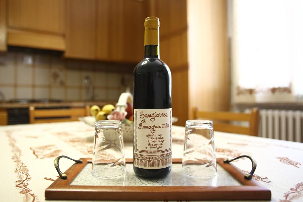 eine Flasche Wein auf einem Tisch mit zwei Gläsern in der Unterkunft RomagnaBNB La Tana del Grillo Parlante in Cesena