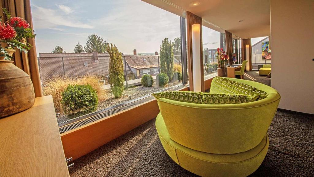 卡爾斯魯厄的住宿－德布勞爾雷特酒店，客厅设有黄色椅子和大窗户