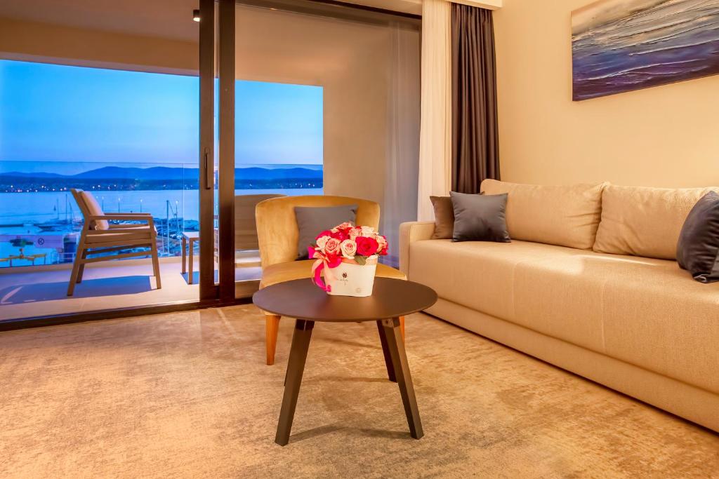 a living room with a couch and a table with flowers on it at Luxury Hotel Riva in Malinska