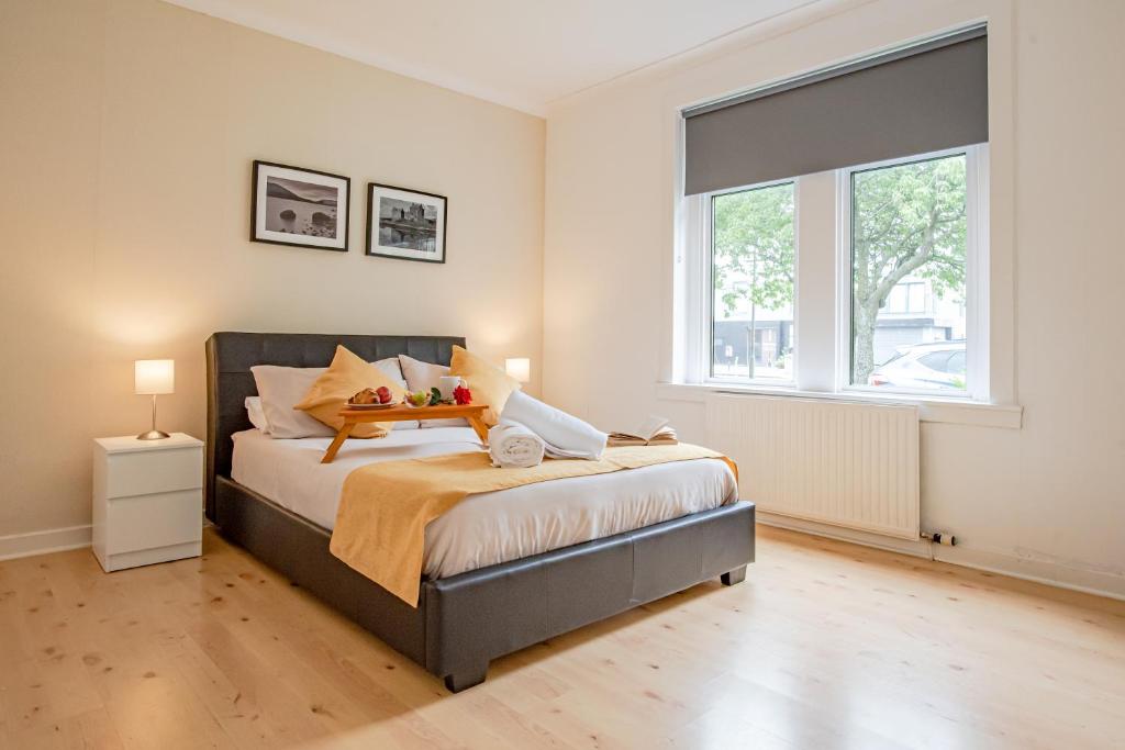 um quarto com uma cama e uma grande janela em Stirling Mercury Apartment - Scotland Holiday Let em Stirling