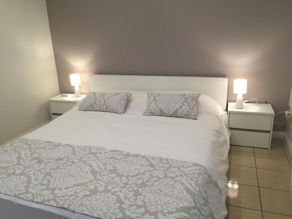 una camera da letto con un grande letto bianco con due comodini di Sun Villa a Saint-Denis