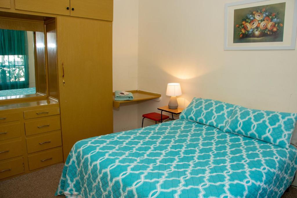 Un dormitorio con una cama azul y una ventana en Kimba Units, en Kimba