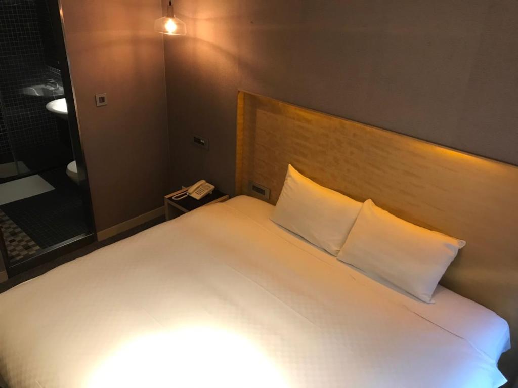Postel nebo postele na pokoji v ubytování 麗馨商旅七賢館