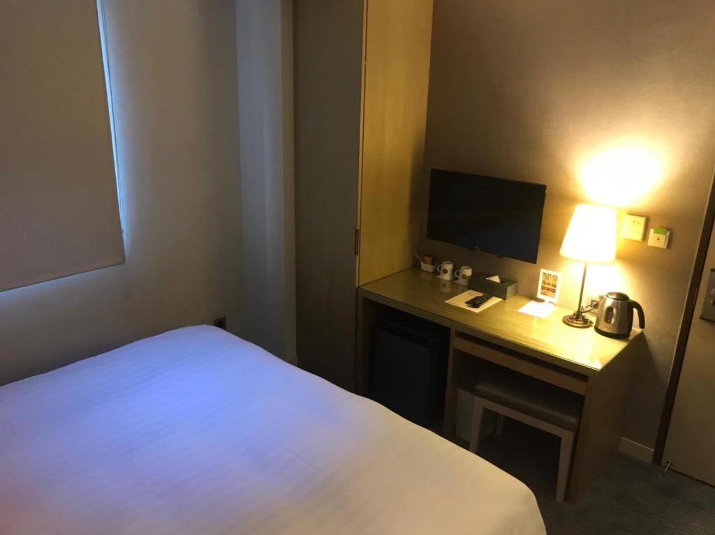 Postel nebo postele na pokoji v ubytování 麗馨商旅七賢館