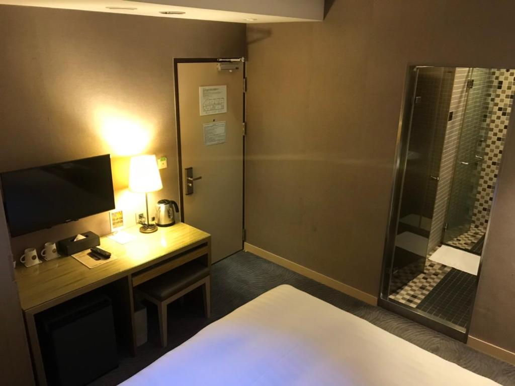 Postel nebo postele na pokoji v ubytování 麗馨商旅七賢館