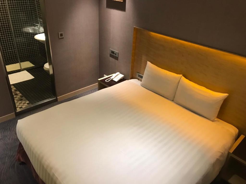 Postel nebo postele na pokoji v ubytování 麗馨商旅七賢館