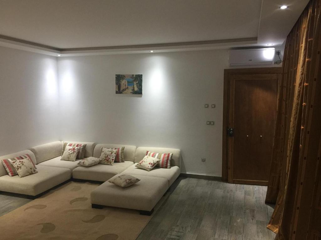 una sala de estar con 2 sofás blancos en una habitación en Penthouse avec vue imprenable sur mer, en Chott Meriem