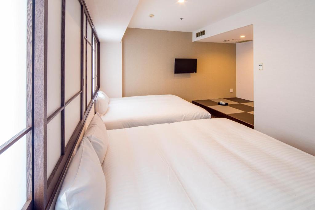 Postel nebo postele na pokoji v ubytování New Osaka Hotel
