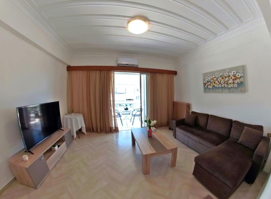 a living room with a couch and a tv at Casa di Sole in Nikiana