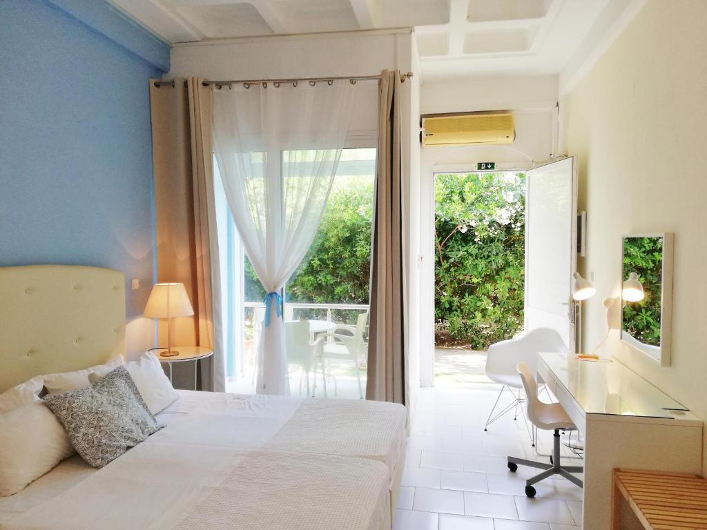een slaapkamer met een bed, een bureau en een raam bij Homely Studios in Chios
