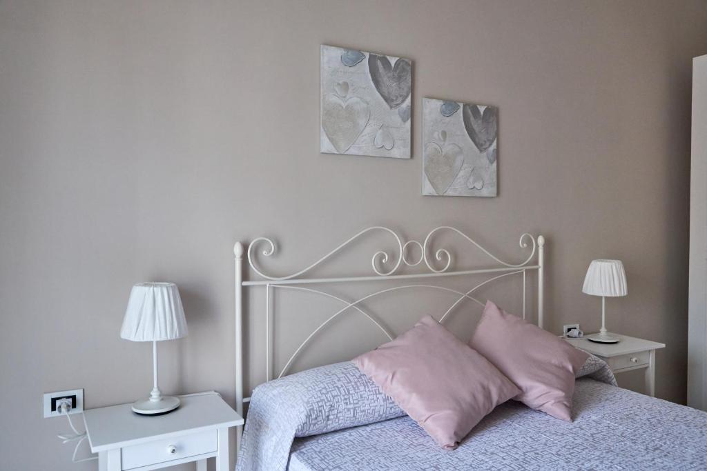 een slaapkamer met een bed met roze kussens en 2 lampen bij Casa Nanni in Napels