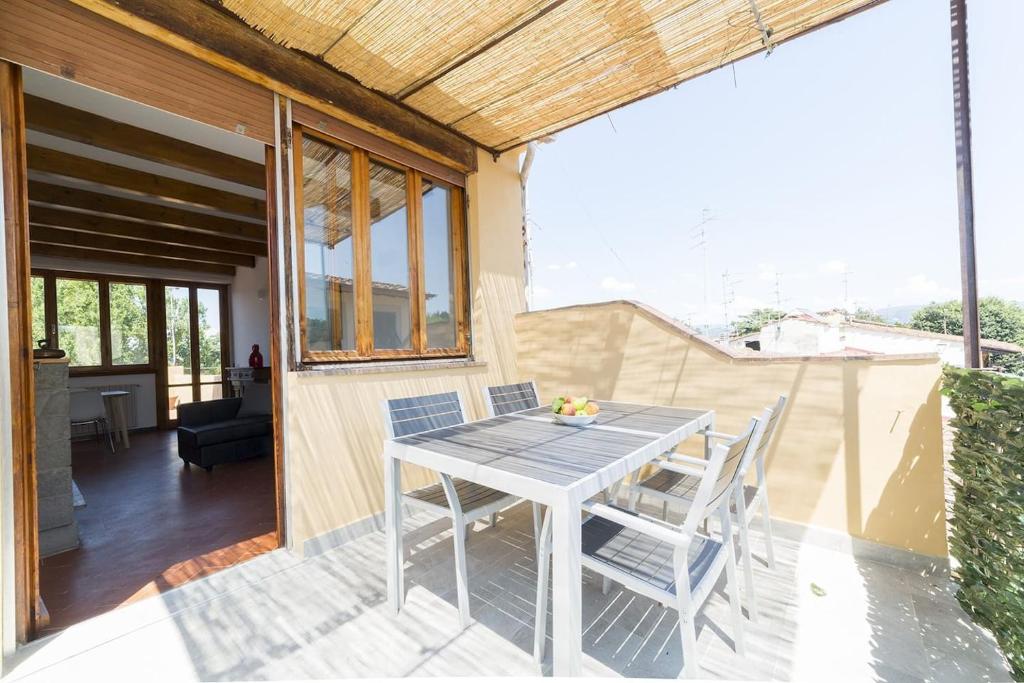 een patio met een tafel en stoelen op een balkon bij Hill's view terrace apartment in Florence