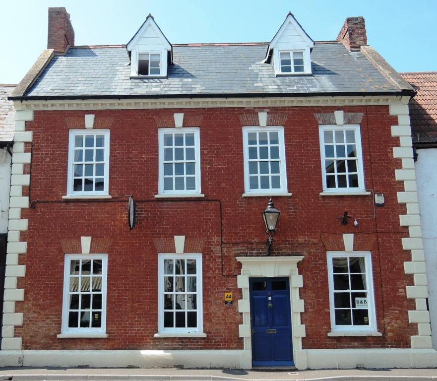 una casa de ladrillo rojo con puerta azul en The Georgian House, en Watchet