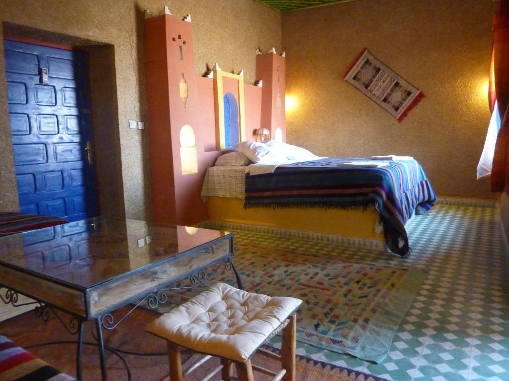 メルズーガにあるKasbah Panoramaのベッドルーム1室(ベッド1台、テーブル、ガラス製テーブル付)