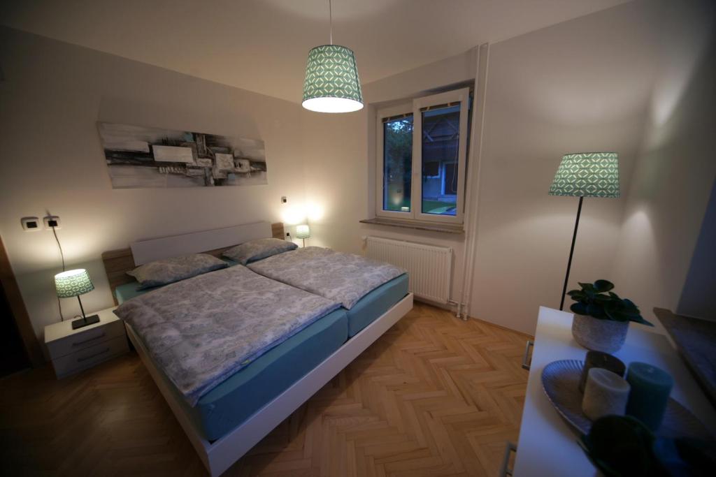 a bedroom with a bed and two lamps and a window at Apartment Arh in Bled