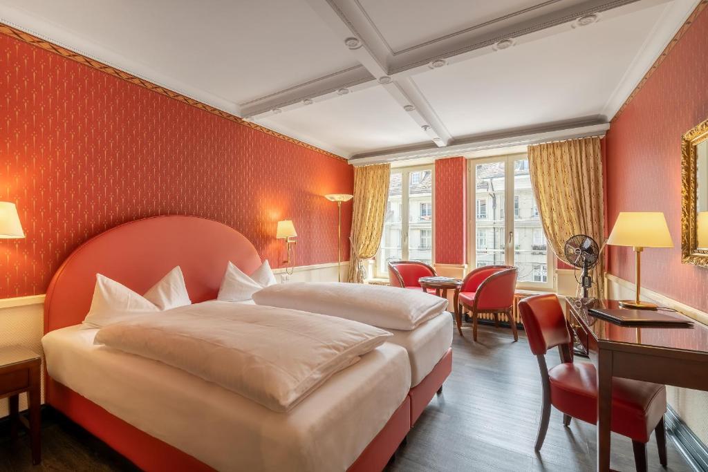 a hotel room with a bed and a table and chairs at Boutique Hotel Belle Epoque in Bern