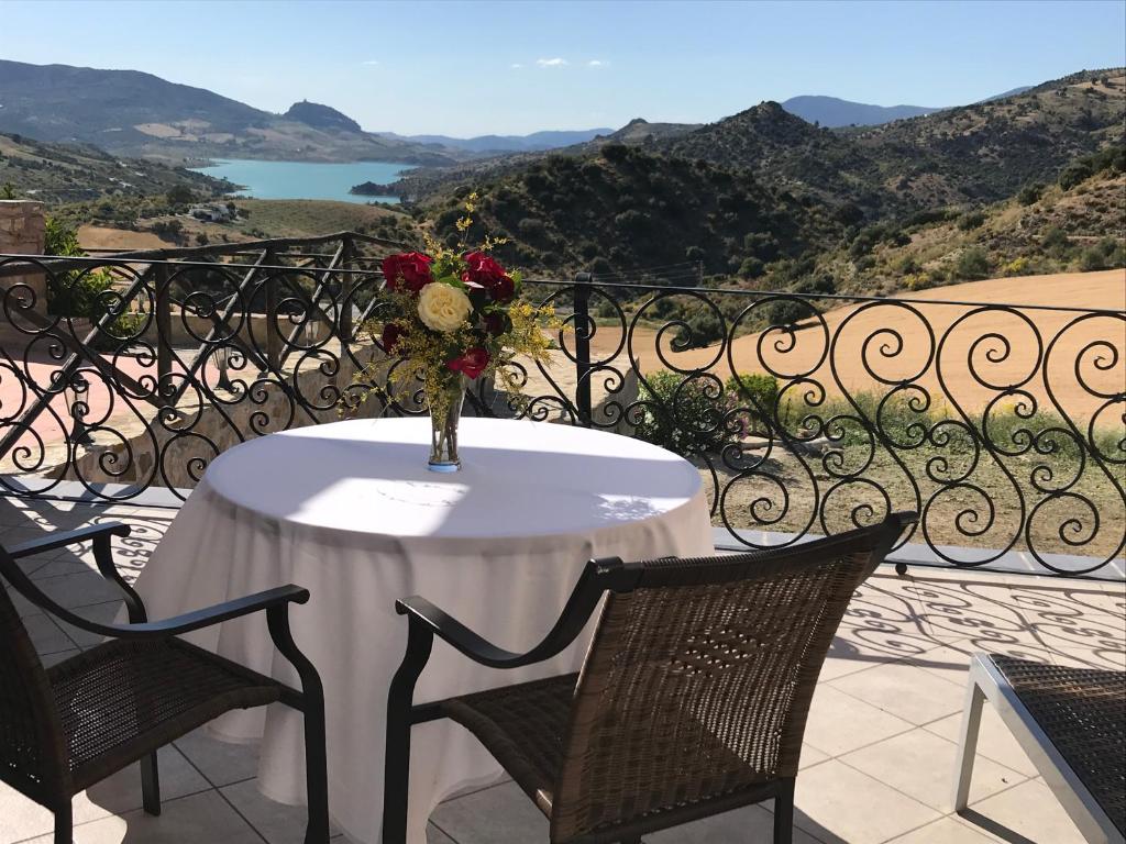 een tafel met een vaas met bloemen op een balkon bij Cortijo Salinas in Montecorto