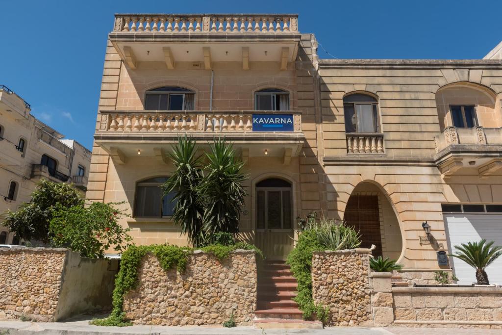 un edificio con un cartel en la parte delantera en Acomodation House Kavarna, en Xagħra